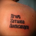 Фото татуировки надписью на спине. Черно-серый рисунок, выполненный готическим шрифтом, символизирующий индивидуальность и убеждения.