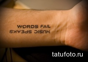 Фото татуировки: надпись "Music Speaks, Words Fail" на руке, выполненная простым шрифтом, символизирующая силу музыки.