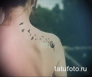 Фото тату одуванчика, из которого разлетаются птицы, на плече. Нежный и романтичный рисунок татуировки выполнен в черном цвете.
