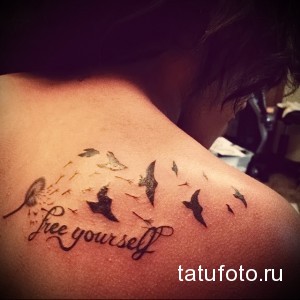 Фото татуировки на плече с изображением летящих птиц и надписью "free yourself". Символизирует освобождение и стремление к независимости.