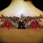 татуировка 2 револьвера на спине девушки и розы - фото
