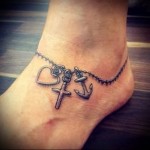 татуировка браслет с разными кулончиками внизу ноги девушки