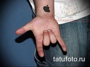 Фото тату логотипа Apple на руке. Черная татуировка, минималистичный дизайн, символ технологической компании.