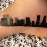 татуировка на ноге силует города