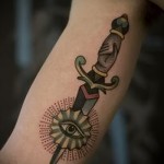 татуировка нож пронзает глаз - работа на руке мужчины - фото