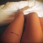 татуировка стрела на ноге девушки