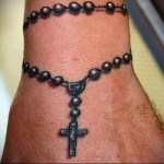 татуировка черные четки с крестом намотанные на руку