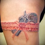 цветная татуировка револьвер и подвязка на правой ноге