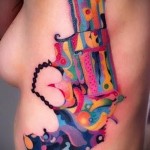цветной пистолет (револьвер) - женская татуировка на боку