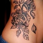 цветок розы с опадающими лепестками - женская татуировка на боку