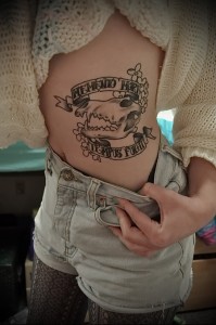 Фото тату черепа с надписями "Memento Mori" и "Tempus Fugit" на боку. Классический стиль с использованием черных чернил.
