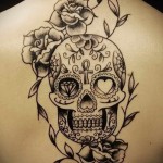 череп и розы темным цветом тату на спине женская