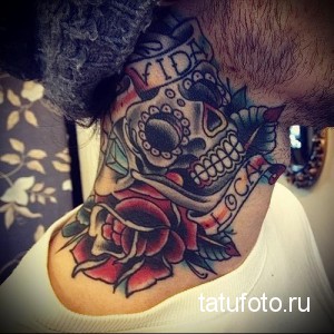 Фото татуировки на шее с изображением черепа в бандане и надписью 'VIDA LOCA'. Выполнена в стиле чикано с использованием ярких цветов и четких линий.