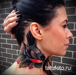 Фото тату на шее с изображением ласточки в стиле олдскул. Рисунок татуировки выполнен в ярких цветах с использованием черных контуров.