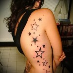 черные и белые звезды - женская татуировка на боку