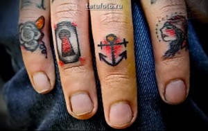 Фото тату на пальцах: набор миниатюрных татуировок: роза, ключ, якорь, птица. Черно-серый рисунок татуировки.