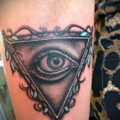 Всевидящее око тату в треугольнике на женской руке