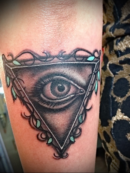 Всевидящее око тату в треугольнике на женской руке