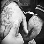 Фотография татуировки в виде звезды на руке, выполненной в черно-белой гамме. Изображение выглядит как традиционная тюремная татуировка.