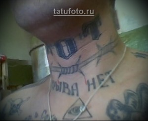 Фото тату на шее: изображение купола, колючей проволоки и надпись "Жива Нет". Тюремная татуировка с символическим значением.