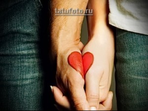 Фото тату: Две руки, соединенные вместе, образующие единое сердце, разделенное пополам татуировками.