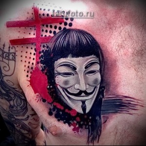 Фото тату маски Гая Фокса с красными брызгами на груди. Стильный и современный рисунок, символизирующий анонимность и борьбу за свободу.