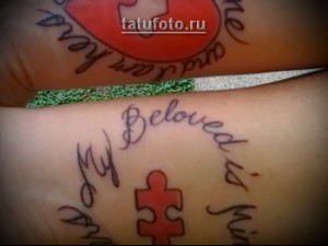 Фото парной татуировки на предплечьях: красные половинки сердца, образующие целое, и надписи 'My heart is yours' и 'and yours is mine'.