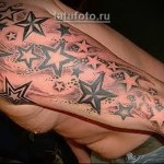 много звезд в татуировке рукавом на руку парня