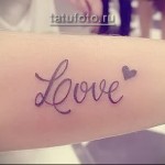 надпись @love@ в татуировке на руке у девушки