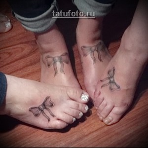 Фото тату: Три женские лодыжки с изящными татуировками в виде небольших черных бантиков. Идеально для парных тату и выражения дружбы.