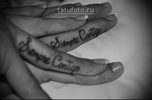 Фото парных татуировок с надписью "Siempre Contigo" (Всегда с тобой) на пальцах. Минималистичный дизайн, черные чернила.