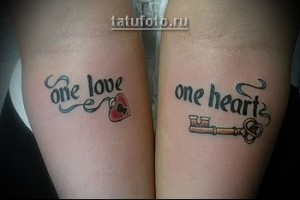Фото парных татуировок на запястьях, изображающих надписи "One Love" с сердцем и "One Heart" с ключом. Черно-серый рисунок.