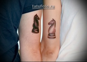 Фото парной татуировки на предплечьях: черный и белый шахматные кони, выполненные в реалистичном стиле с детальной проработкой.