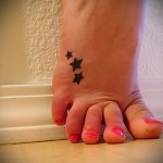 три маленькие звездочки в элегантной татуировке на женской ноге