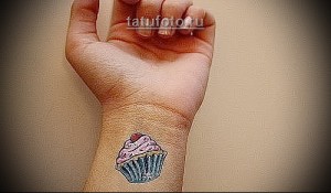 Фото тату: яркая и аппетитная татуировка капкейка на запястье. Сладкий и забавный рисунок татуировки для девушек.