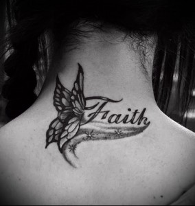 Фото тату бабочки и надписи 'Faith' на задней части шеи. Черно-белая татуировка с детально проработанными крыльями бабочки и красивым шрифтом.