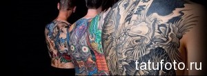 Фотография трех мужчин с масштабными татуировками в японском стиле на спине. Изображены драконы, карпы кои и другие традиционные символы.