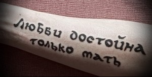 Фото тату на предплечье с надписью на русском языке: "Любви достойна только мать". Минималистичный эскиз тату, выражающий глубокое чувство.