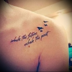 Фото татуировки с вдохновляющей фразой 'inhale the future exhale the past' и тремя маленькими птичками, выполненной на плече.