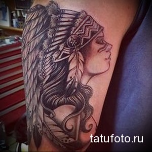 Фото тату на руке: изображение профиля индианки с длинными волосами и перьями, выполненное в черно-серых тонах. Рисунок детализированный и элегантный.