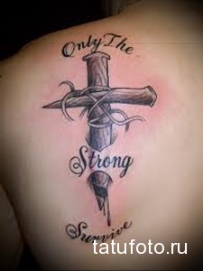 Фотография татуировки креста с надписью 'Only The Strong Survive' и изображением капель крови на спине. Рисунок выполнен в черно-серых тонах с использованием реалистичных деталей.