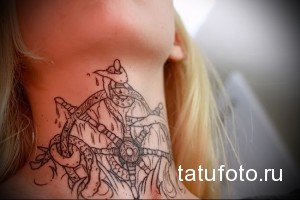 Черно-белая татуировка на шее, изображающая сложное мифологическое существо с рогами и орнаментами, выполненная в графическом стиле.