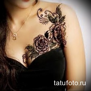 Фото тату с изображением пионов и декоративных узоров на плече. Красивый и оригинальный рисунок татуировки.