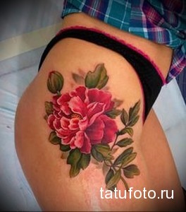 Фото тату с изображением розового пиона на бедре. Красивый и женственный рисунок татуировки.
