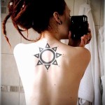 татуировка солнце между лопаток красивой молодой девушки - фото селфи в зеркало