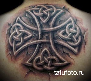 Фото татуировки кельтского узла на спине, между лопатками. Черно-серый рисунок с эффектом объема и трещин.