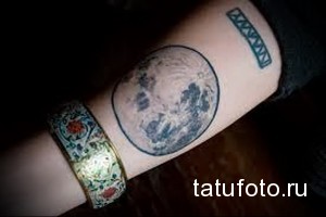Фото тату с изображением луны и римских цифр. Оригинальный рисунок татуировки в черно-зеленой гамме.