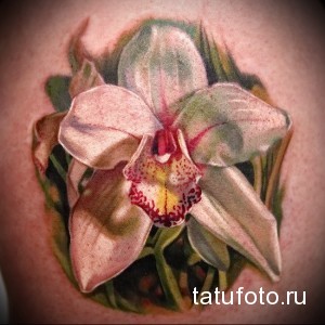Фото тату орхидеи на руке. Детализированный рисунок татуировки с реалистичной проработкой лепестков и нежных оттенков. Идеальный эскиз тату для любителей флористики.