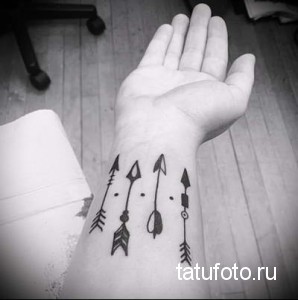 Фото тату: несколько стрел разного дизайна на запястье, выполненные в черном цвете, создающие уникальный браслет.