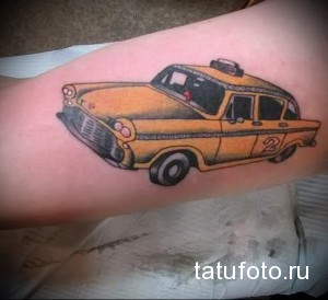 Фото тату с изображением желтого такси в стиле ретро на руке. Яркий и стильный рисунок татуировки.